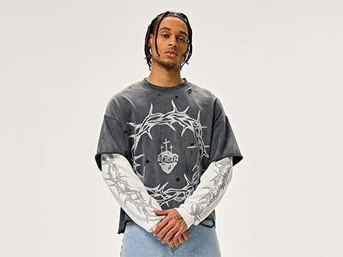 Production 21 Close-up of a model in a distressed faux-layer sweatshirt with a ripped detail.