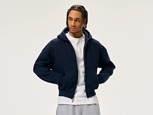 Model in a navy blue zip-up hoodie with a front pocket.
