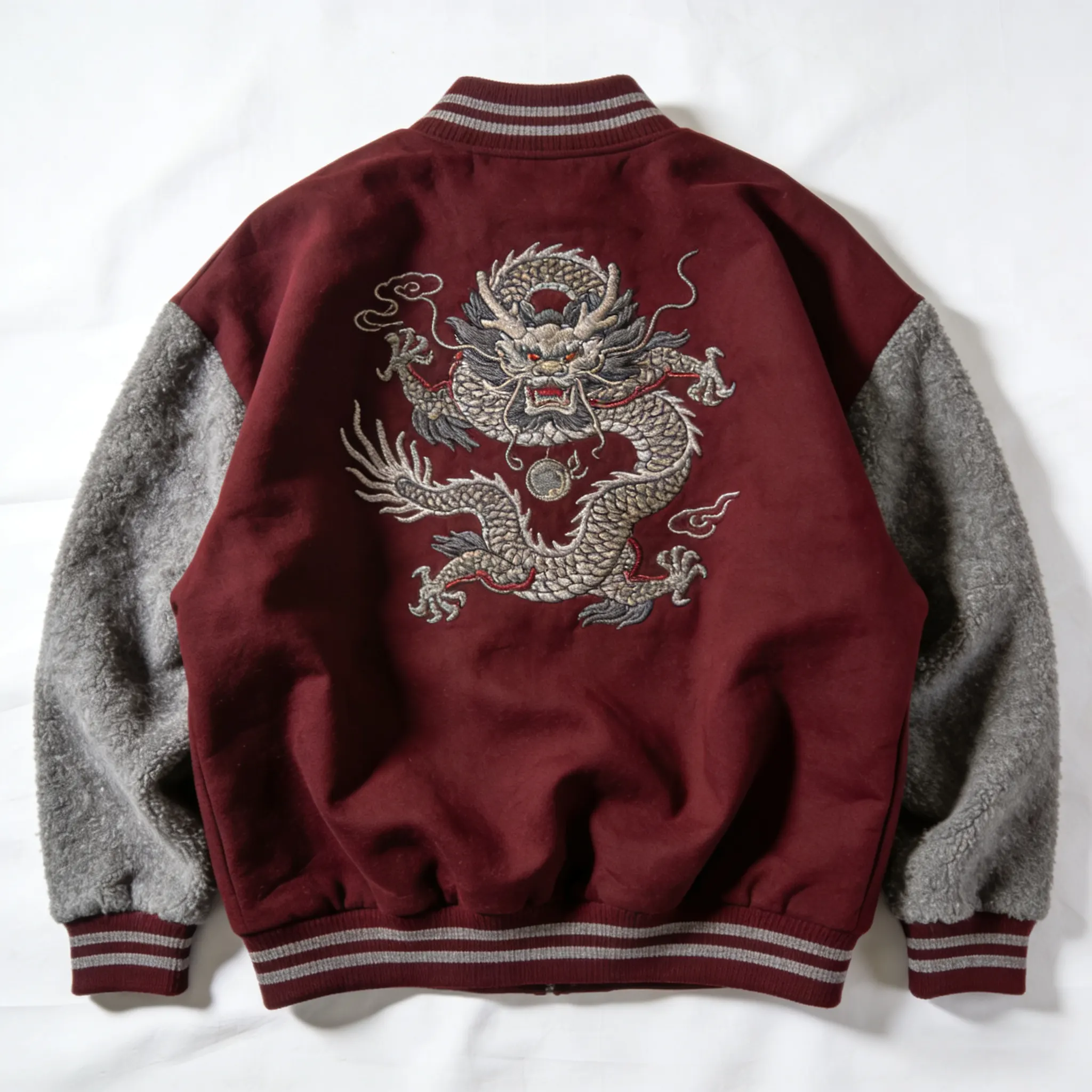 an oversized varsity jacket in a deep burgundy color with contrasting grey sleeves made of boiled wool