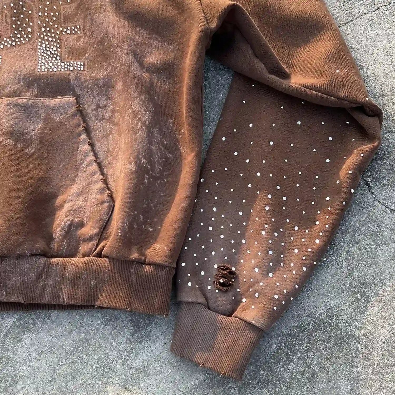 Detail of hand-frayed ribbed hem and scattered rhinestone sleeve embellishments for bespoke clothing brands