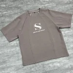 Angled flat lay highlighting the curved paneling on the custom cut and sew streetwear t-shirt