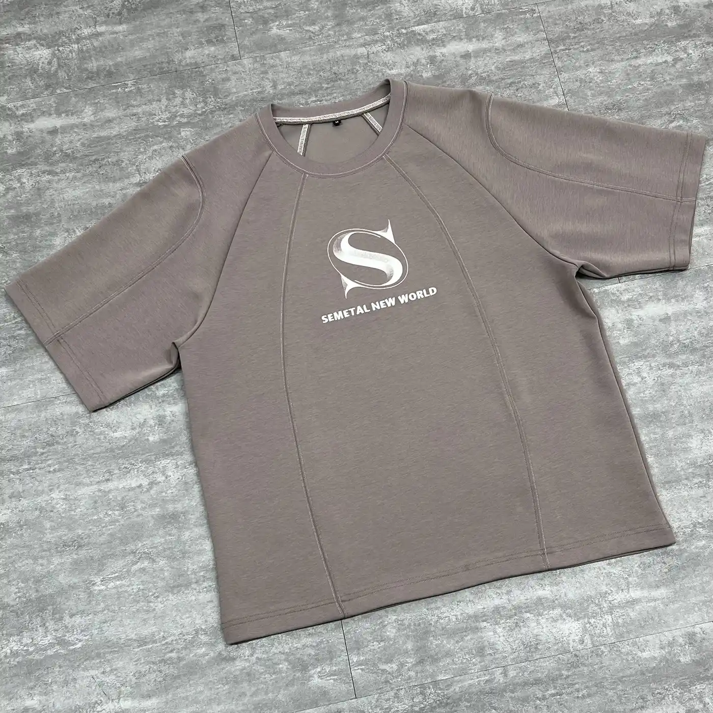Angled flat lay highlighting the curved paneling on the custom cut and sew streetwear t-shirt