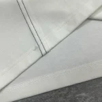 Macro detail of the double-needle diagonal stitching and hem on the premium streetwear manufacturer tee