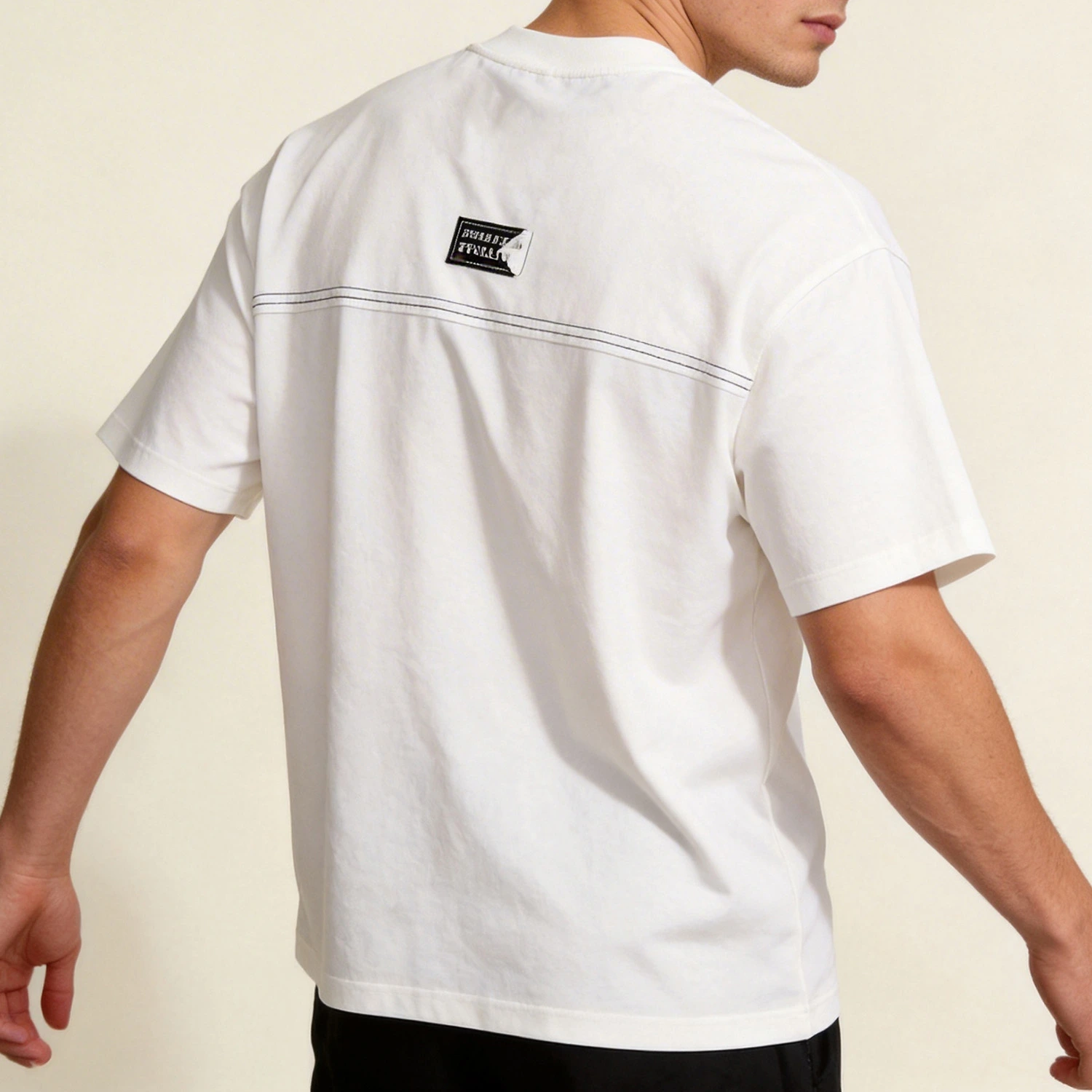 Male model wearing the custom woven label oversized t-shirt showing the back horizontal seam detail