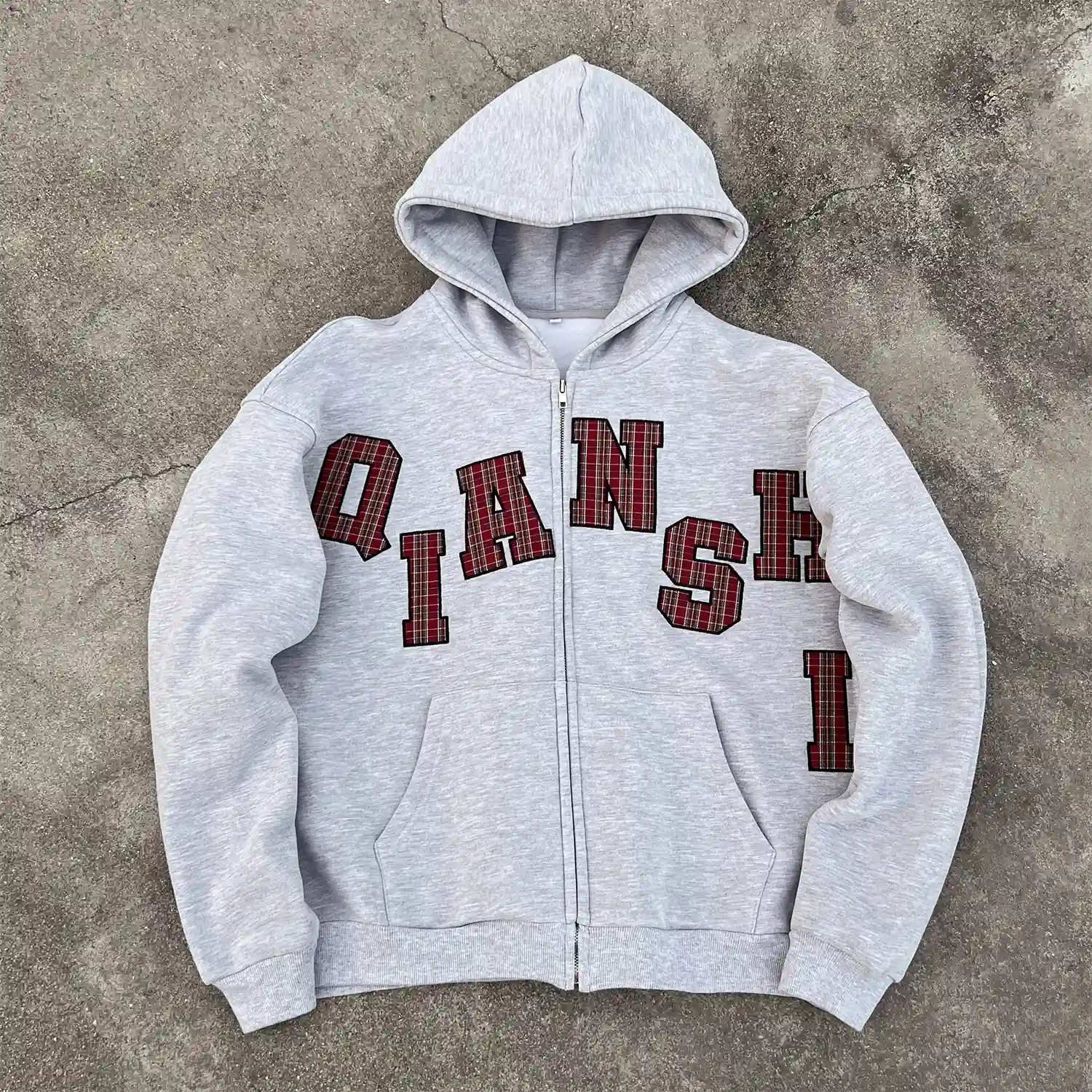 Front flat lay of heather grey custom applique zip up hoodie for streetwear brands.
