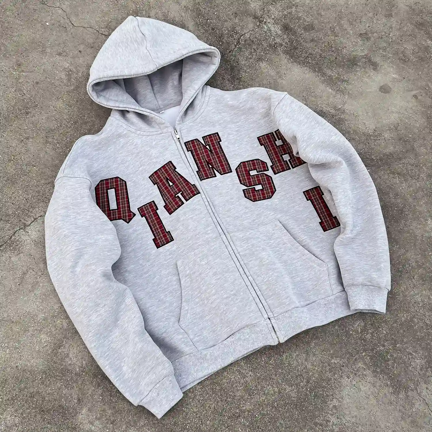 Angled front view of oversized 400GSM fleece zip hoodie with plaid embroidery.
