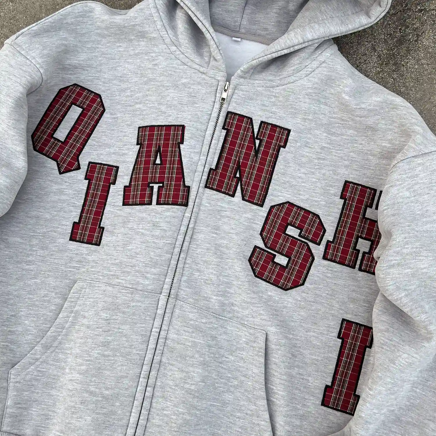 Close up of arched tartan plaid lettering on custom applique zip up hoodie.