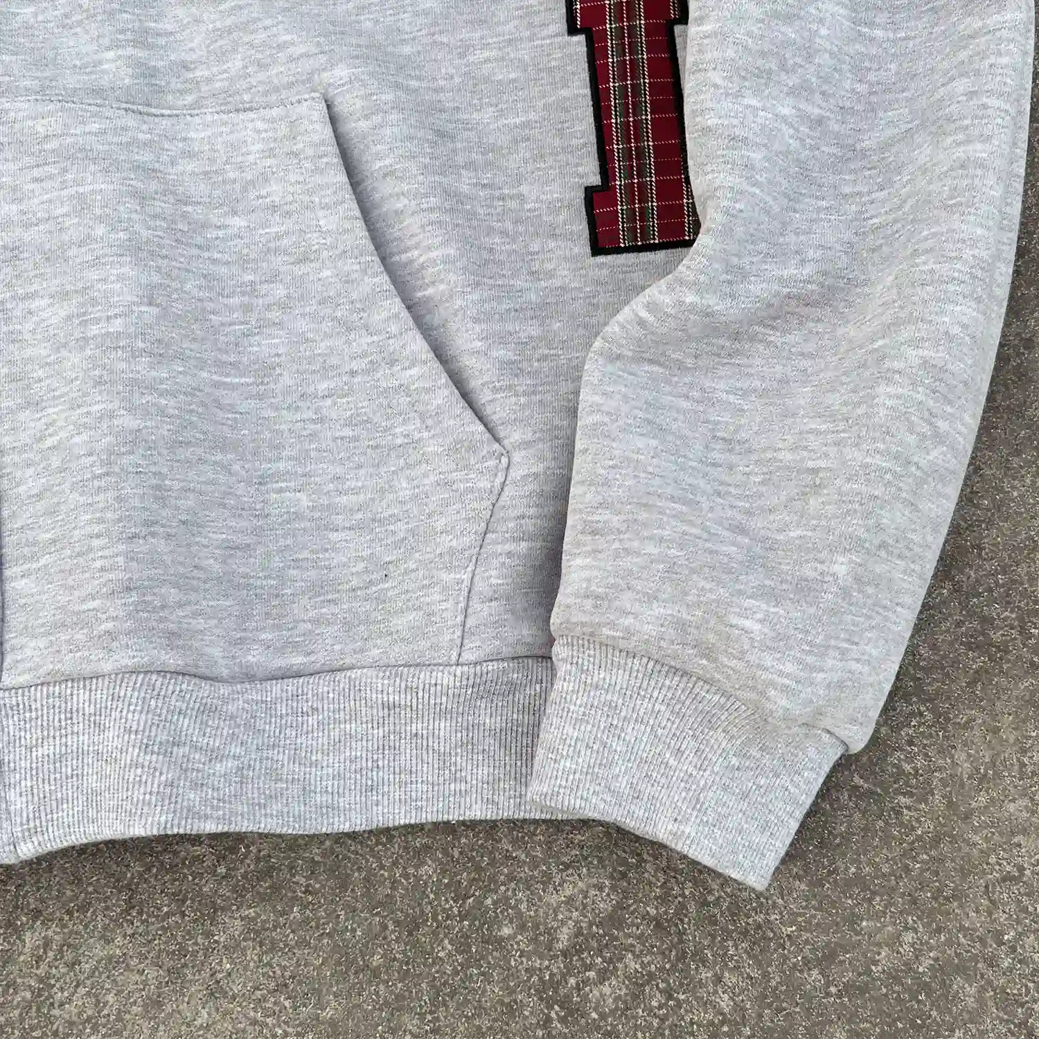 Detail shot of ribbed cuff and split kangaroo pocket on wholesale streetwear hoodie.