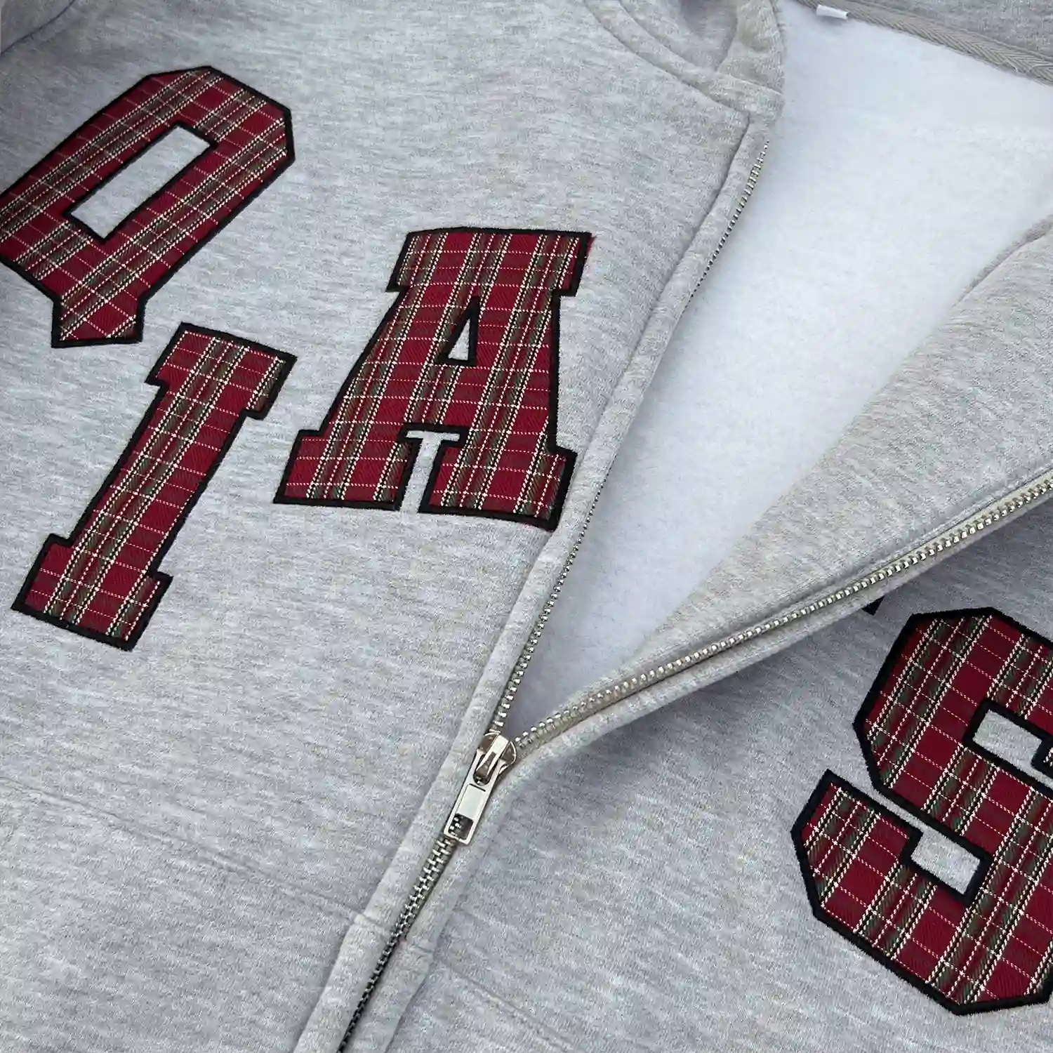Close up of metal zipper and brushed fleece interior lining on OEM clothing.