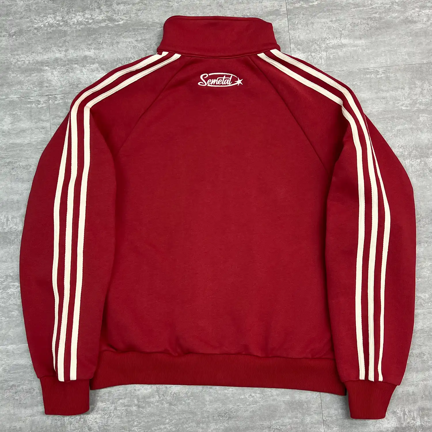 Close-up of high-density back neck star embroidery on premium custom track jacket.