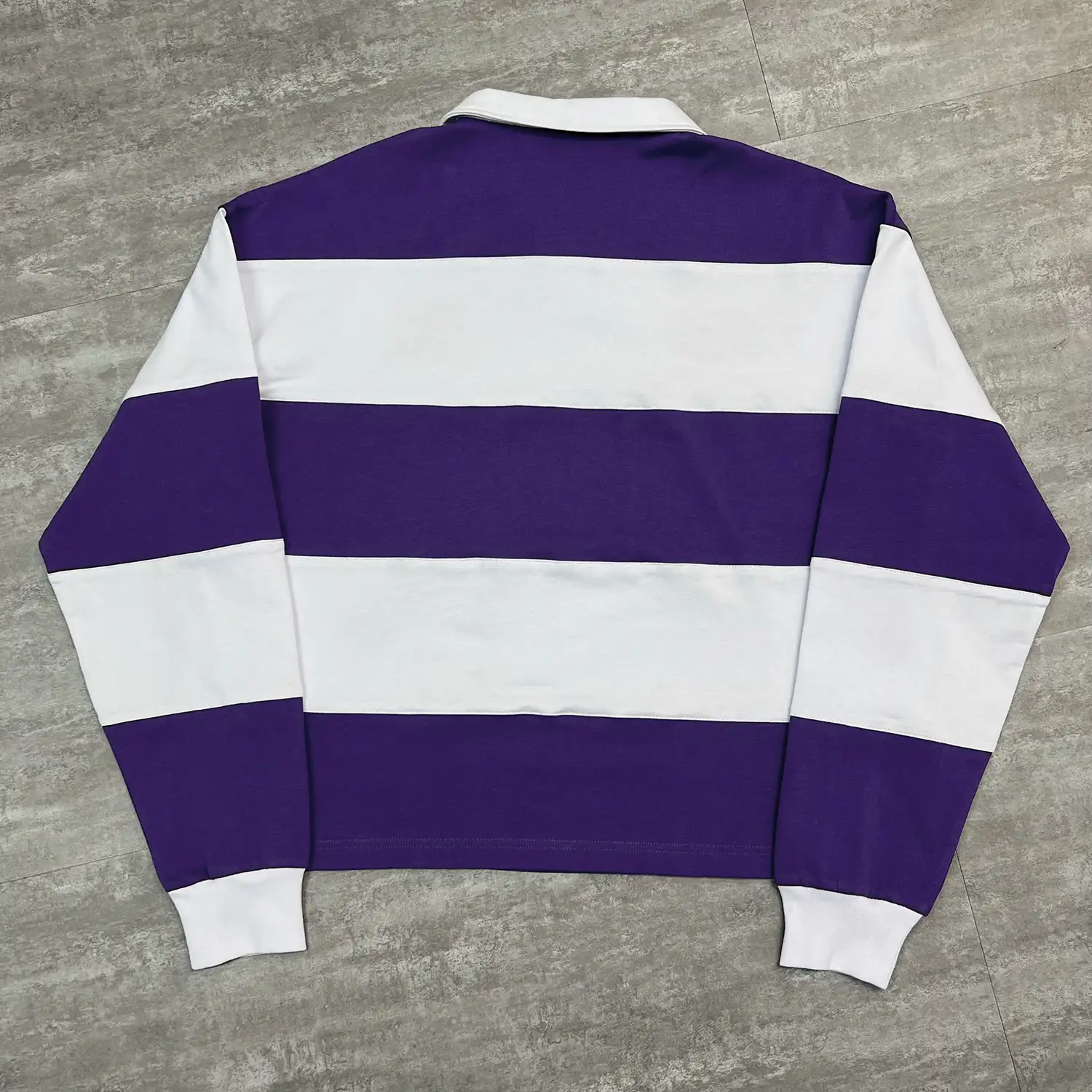 Full back view of purple and white custom striped polo shirt with twin-needle hem.