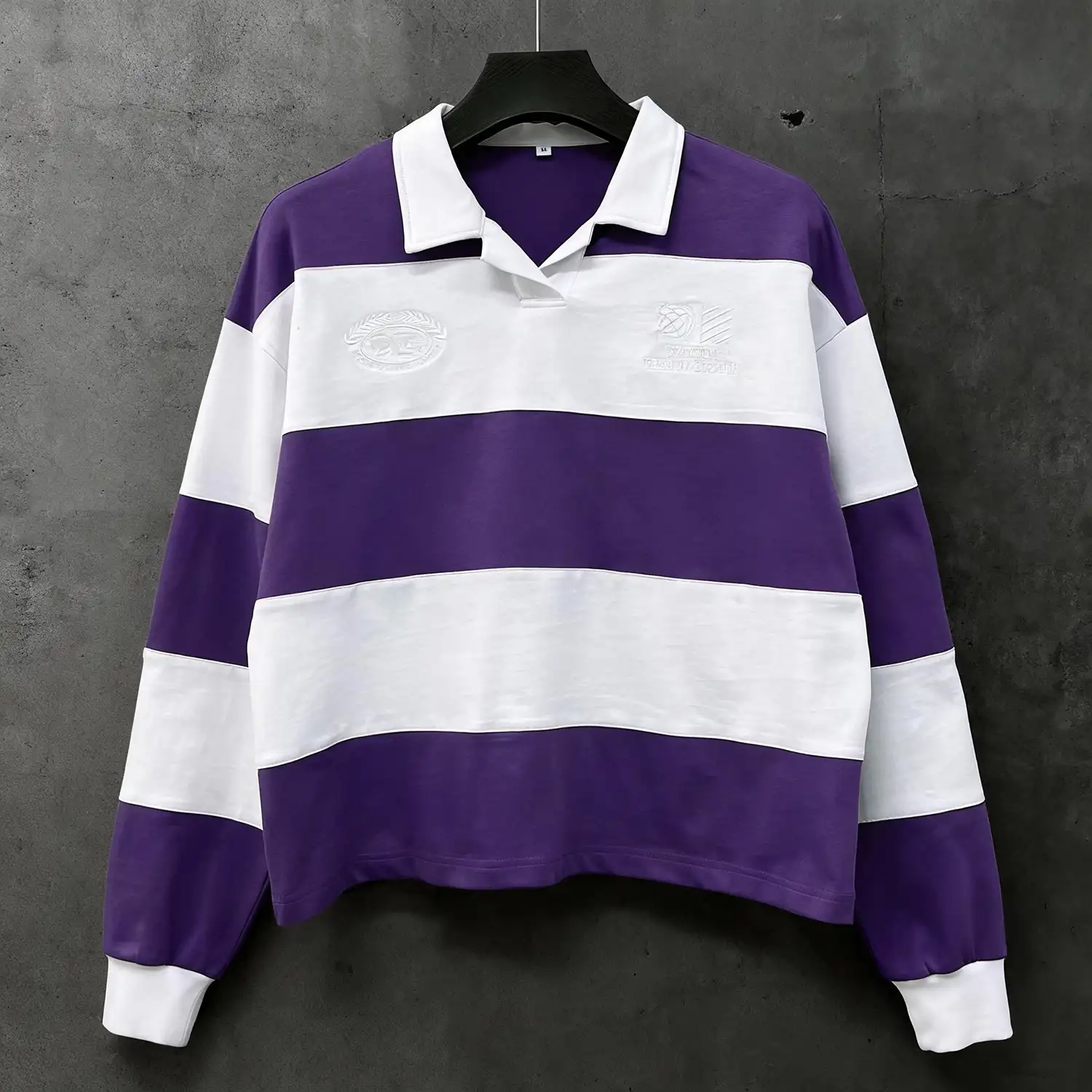 Front view of custom striped polo shirt hanging on a rack for OEM apparel display.