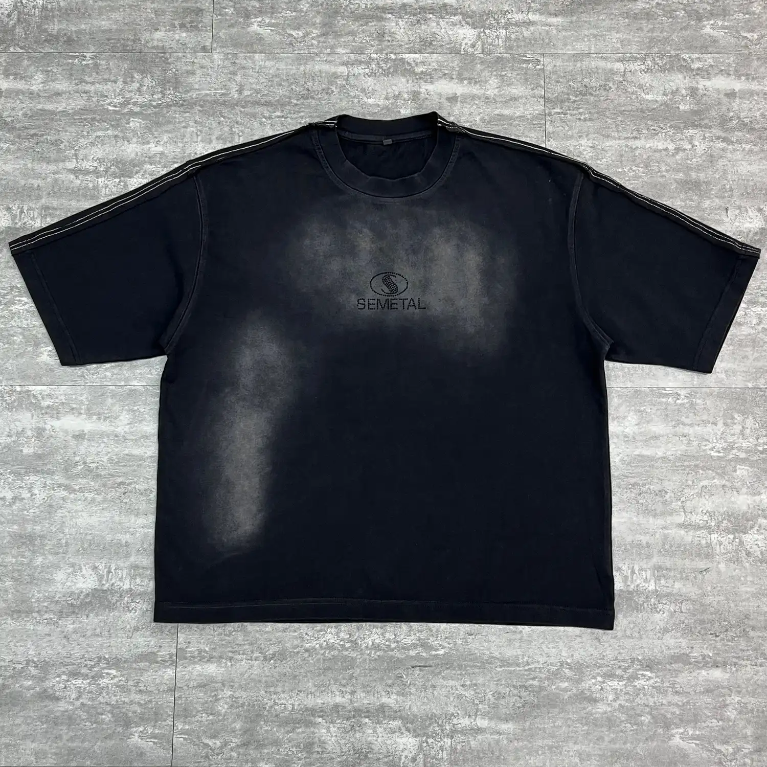 Flat lay front view of black custom washed oversized t-shirt with rhinestone logo.