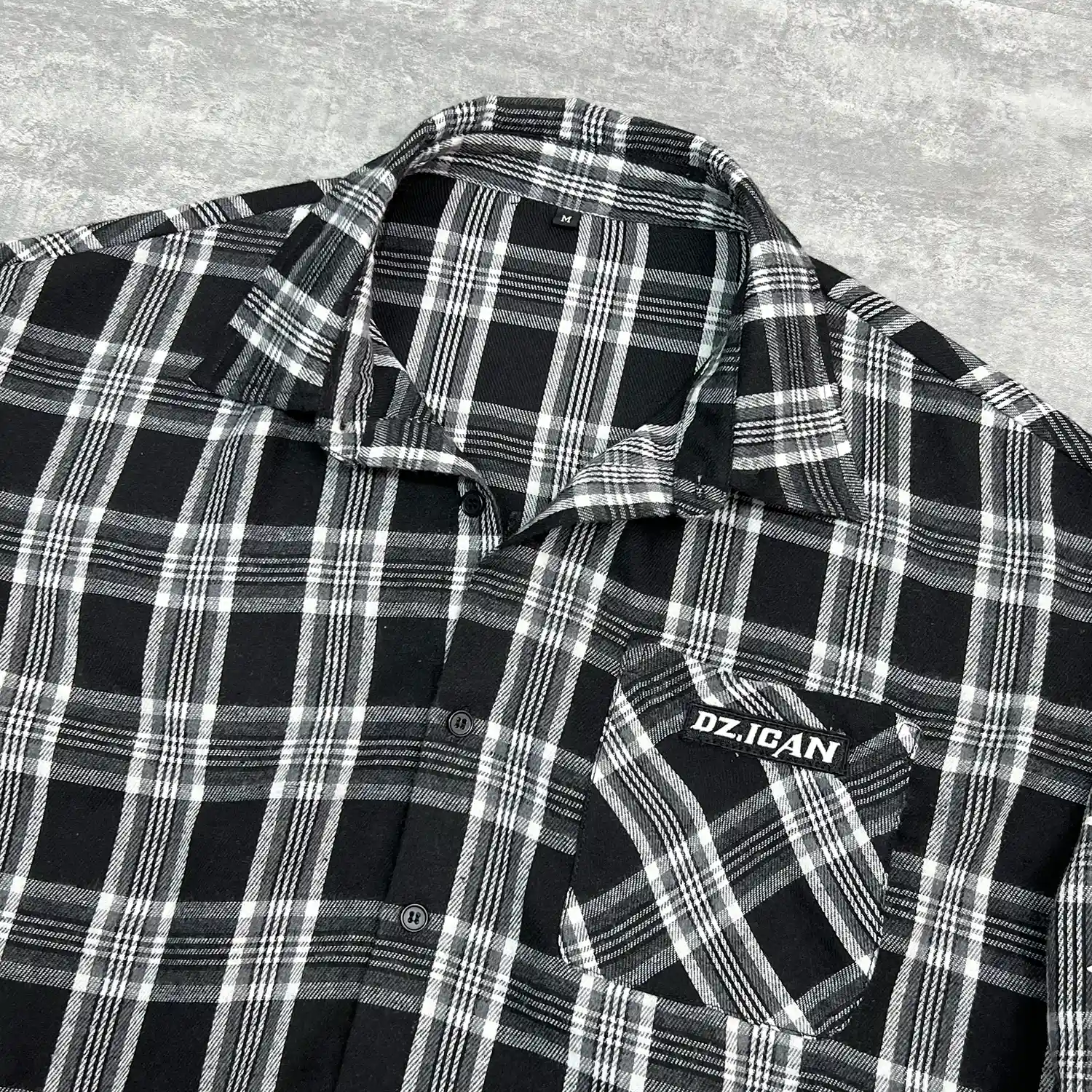 Detailed view of sleeve raw edge and white exposed stitching on mesh top.